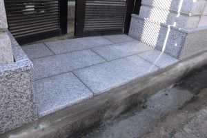 住宅玄関石貼り工事の写真です。板石表面はバーナー仕上げなので雨の日も足元が汚れず快適です。